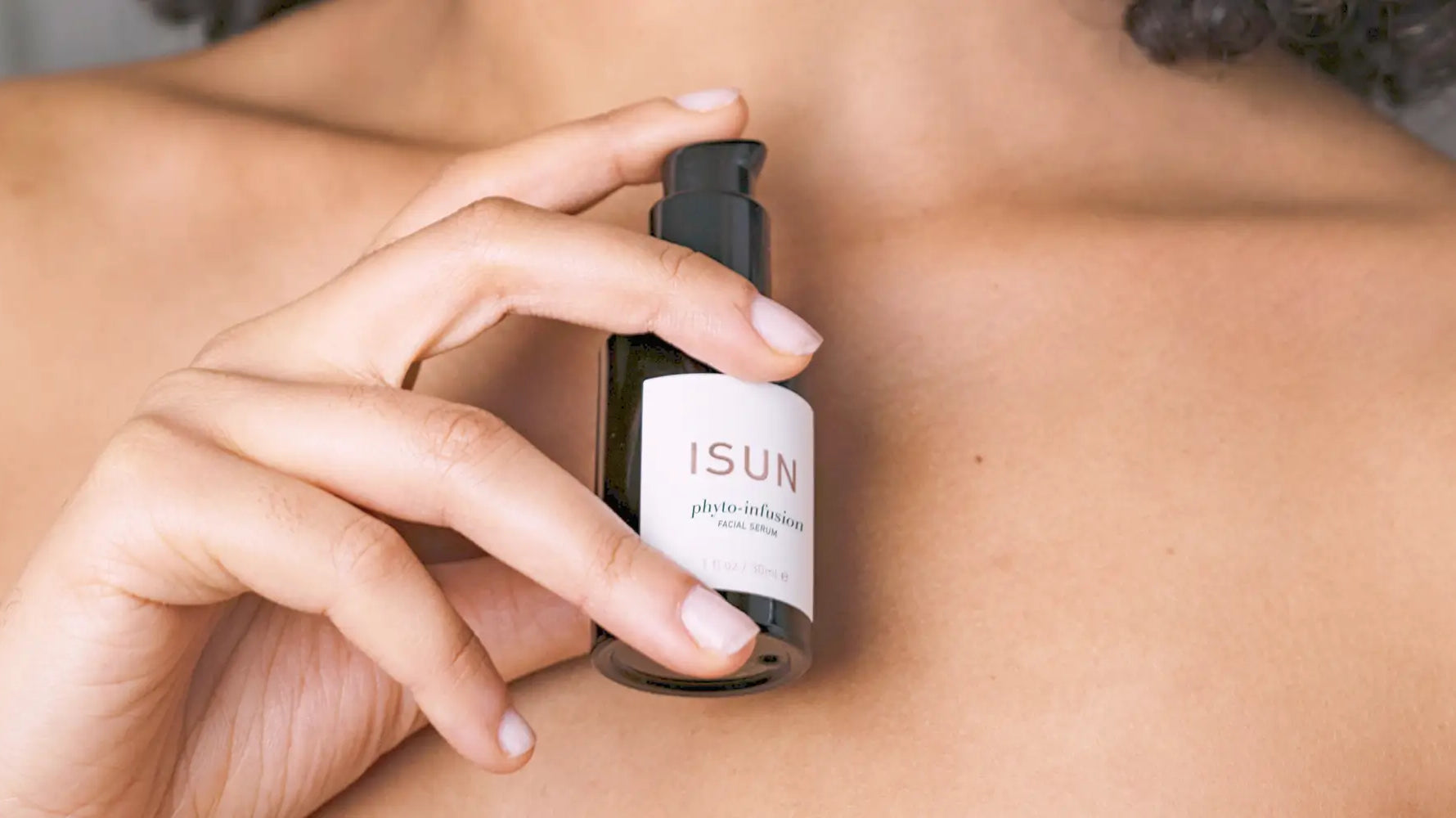 girl holding a bottle of Isun Phyto Infusion close to her chest