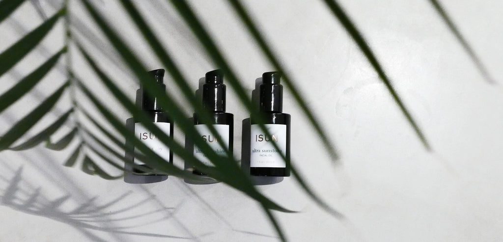 ISUN Facial Oil Moisturizers and palm plant reflection
