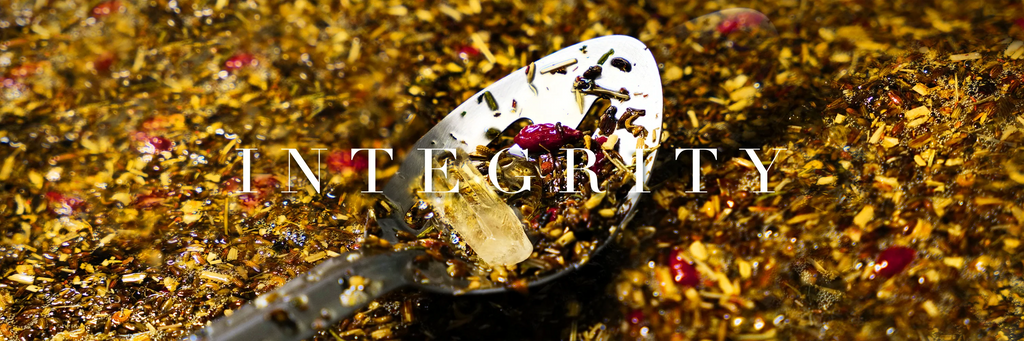 Sppon with a quartz stone resting in a herbal oil infusion