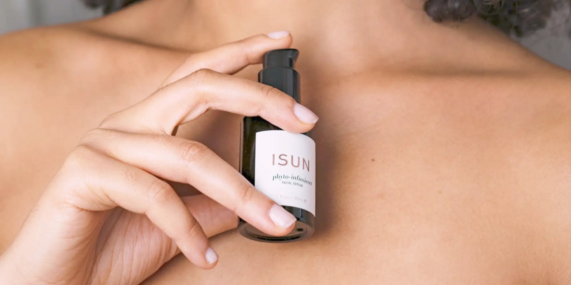 girl holding a bottle of Isun Phyto Infusion close to her chest