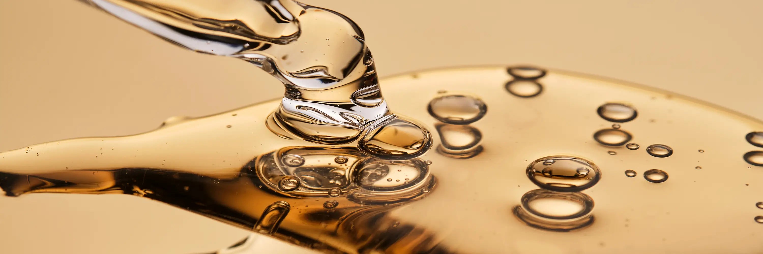 Golden liquid with bubbles flowing from a pipette