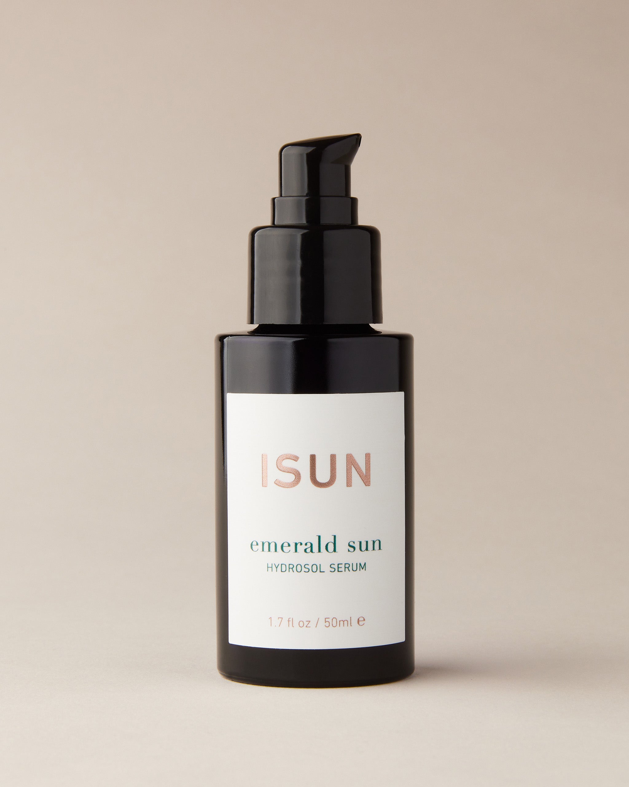 Bottle of ISUN Emerald Sun Hydrosol Serum on beige background