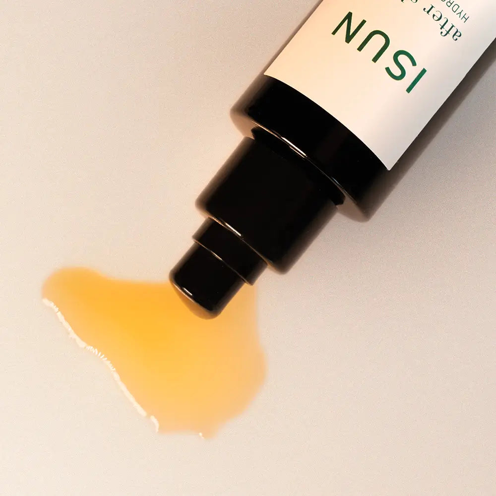 ISUN after shave balm with a droplet of yellow liquid on a beige background