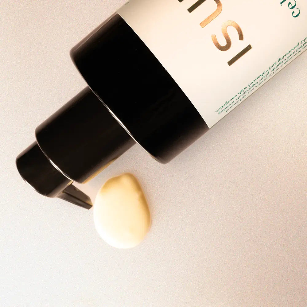 Cosmetic bottle with a droplet of cream on a light background
