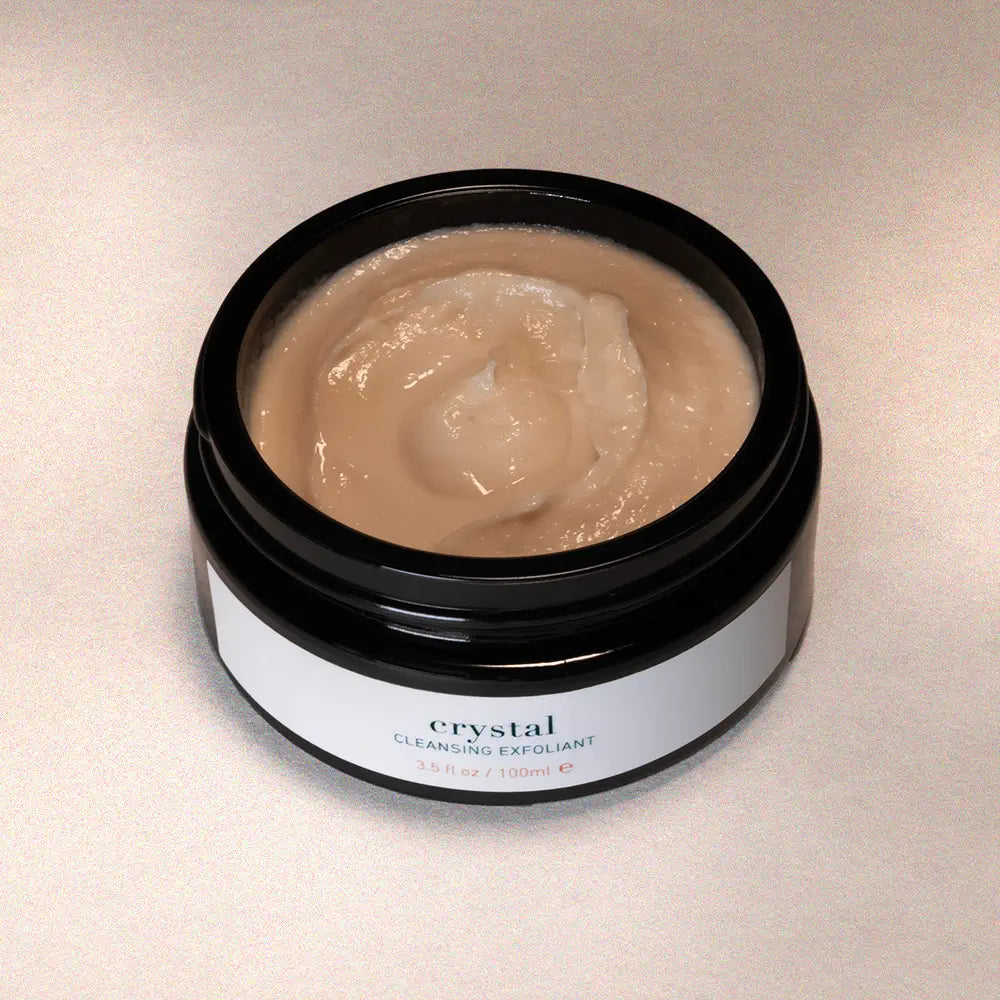 Jar of 'Crystal' cleansing exfoliant on a beige background