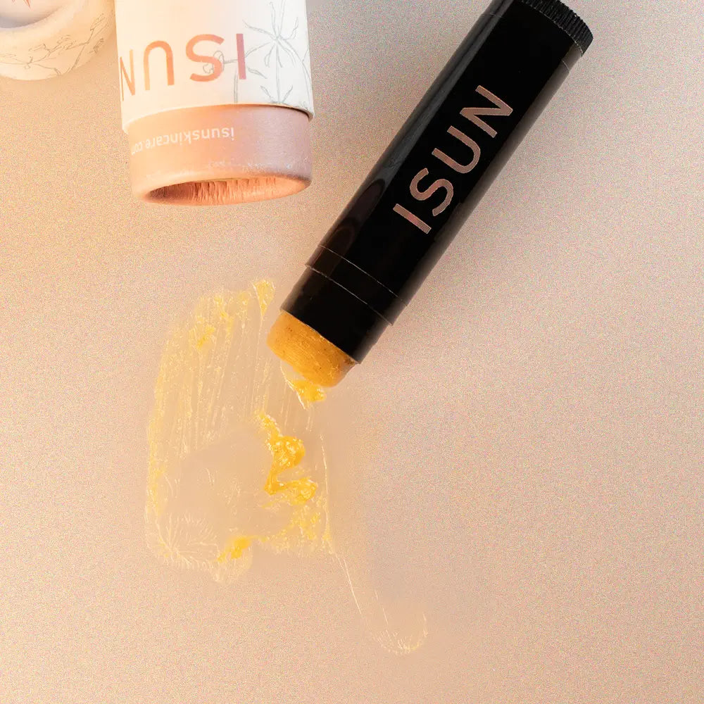 ISUN lip balm with yellow cream on a beige background