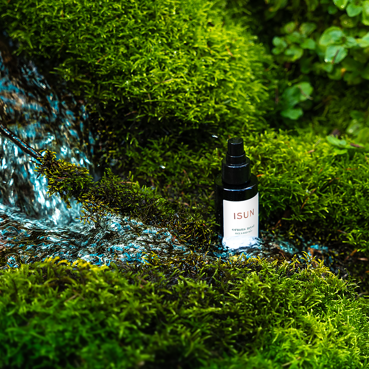 ISUN bottle on a mossy background with water flowing