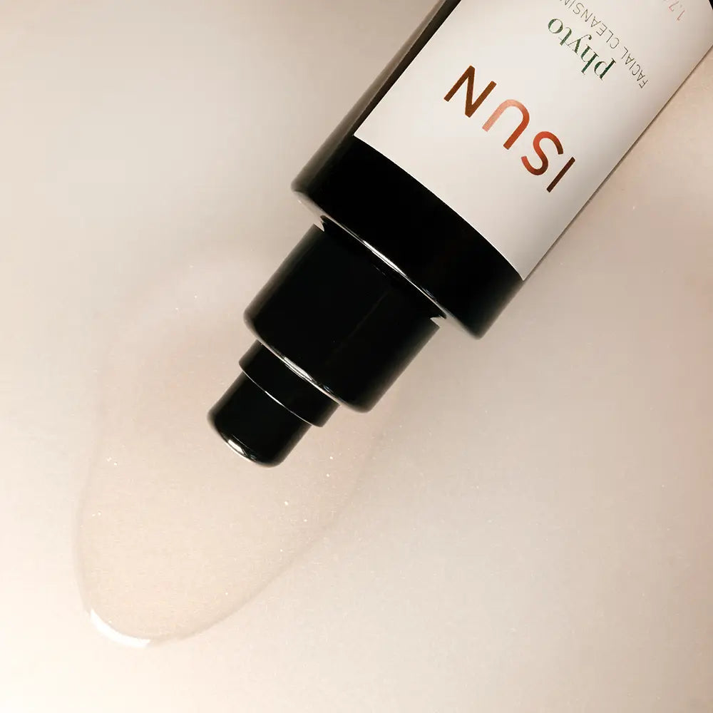 Close-up of a skincare bottle with 'ISUN' branding on a beige background