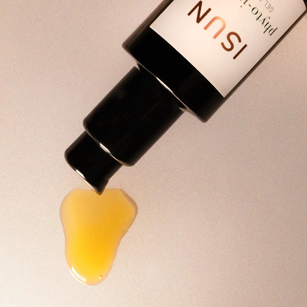 ISUN skincare product with yellow gel oozing out on a beige background