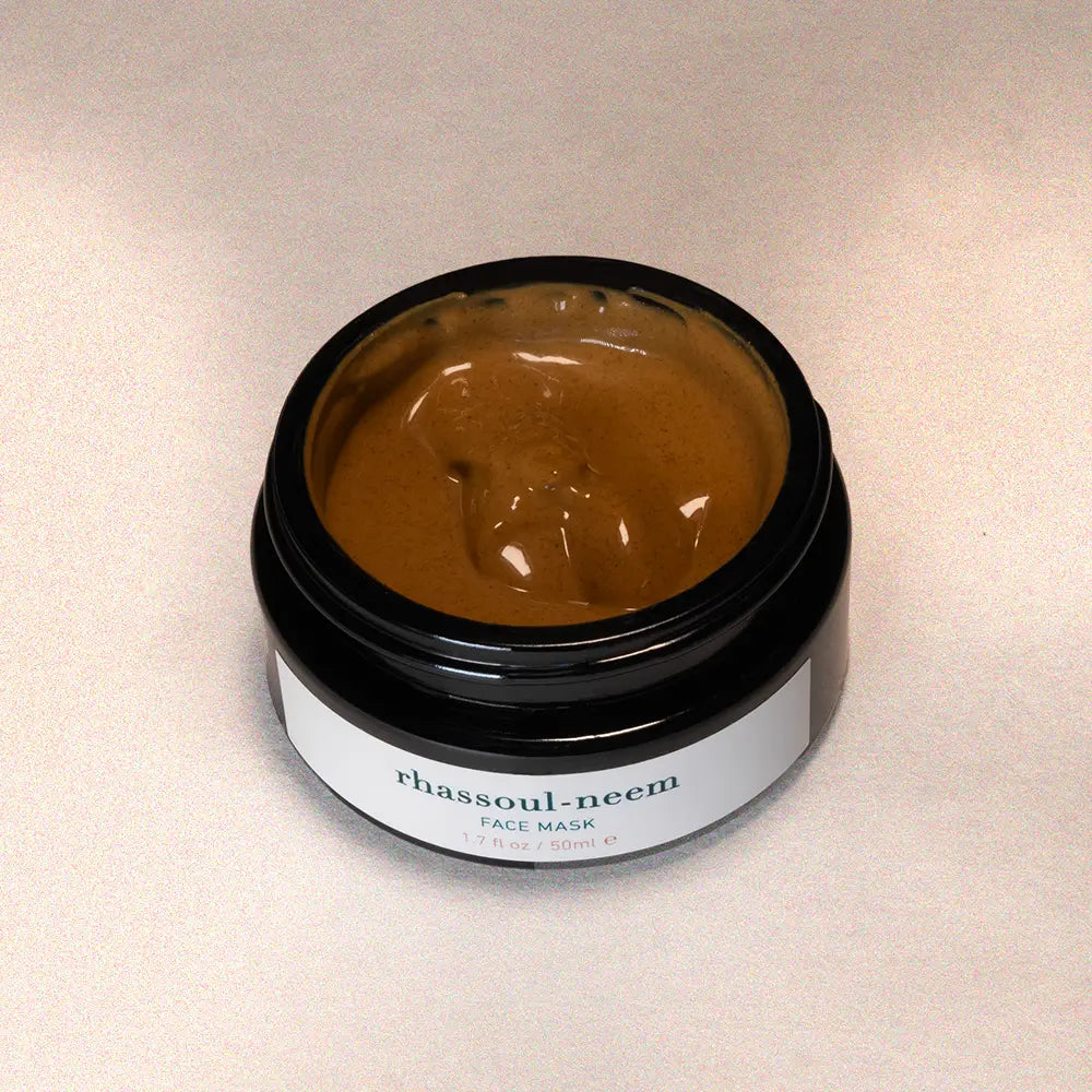 Jar of rhassoul-neem face mask on a beige background