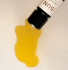 Yellow liquid spilling from a bottle labeled Sacred on a beige background