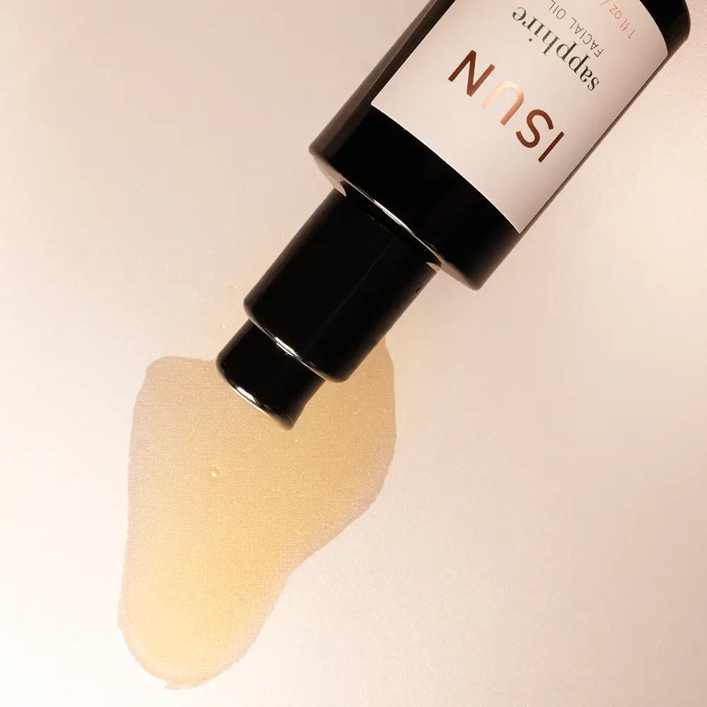 ISUN skincare product with a droplet of oil on a beige background