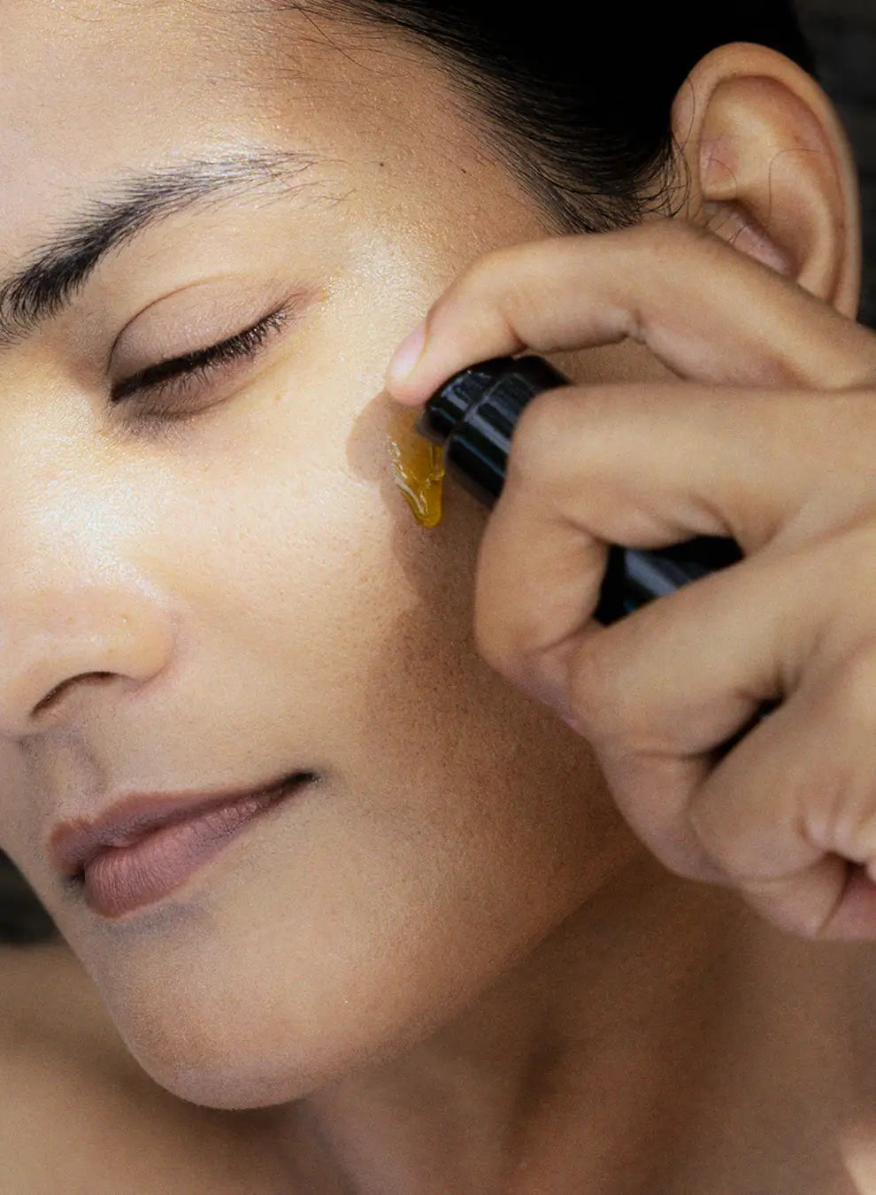 Person applying a cosmetic product to their face with a brush
