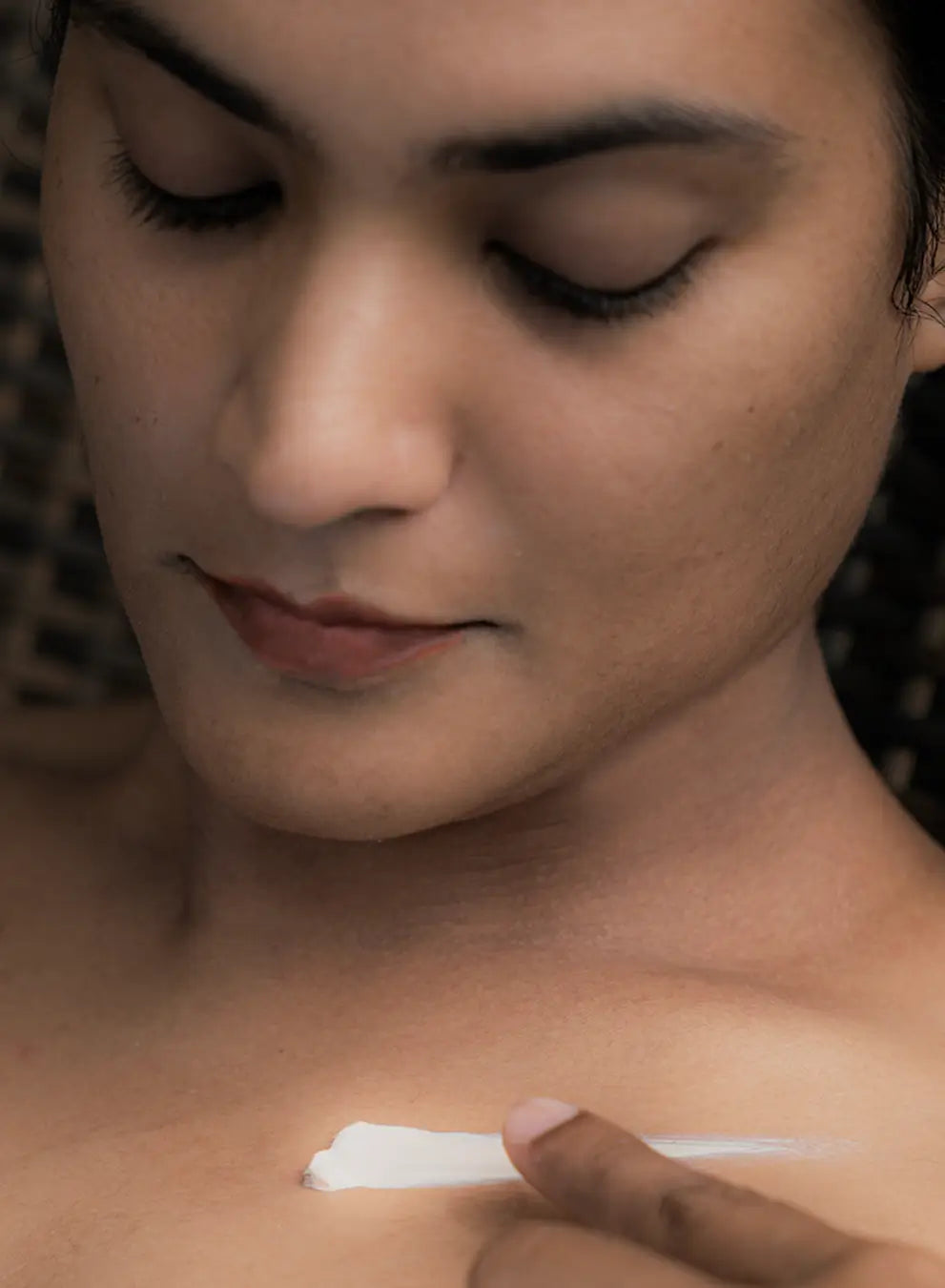 Person applying a white cream to their shoulder