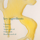 Golden oil and text listing key ingredients on a beige background