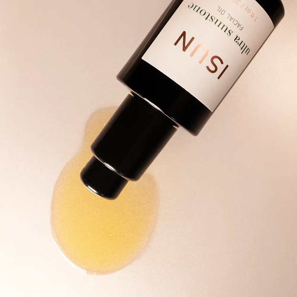 Bottle with yellow oil and ISUN label on a beige background