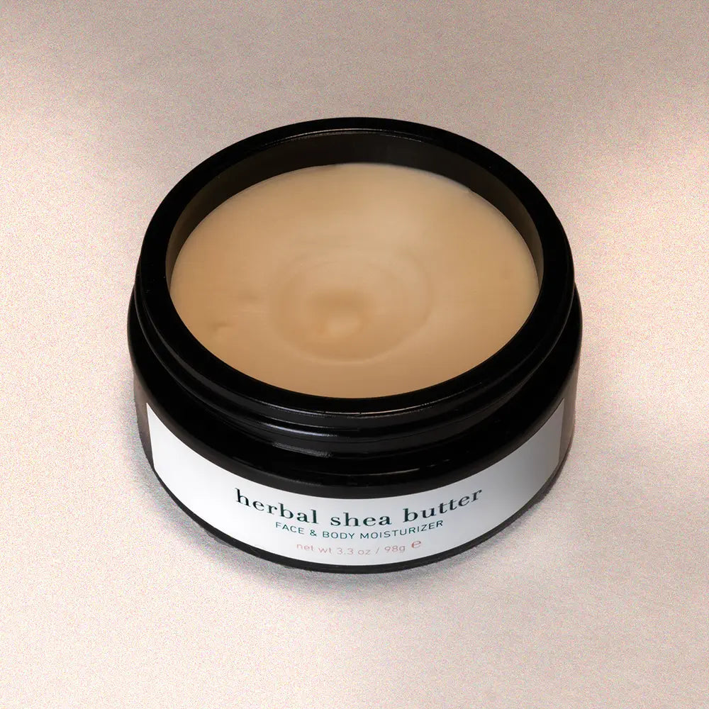 Jar of herbal shea butter on a light background