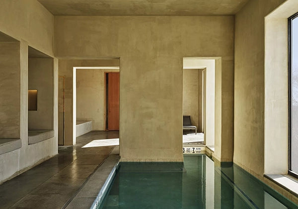Modern indoor pool area with concrete walls and floor.