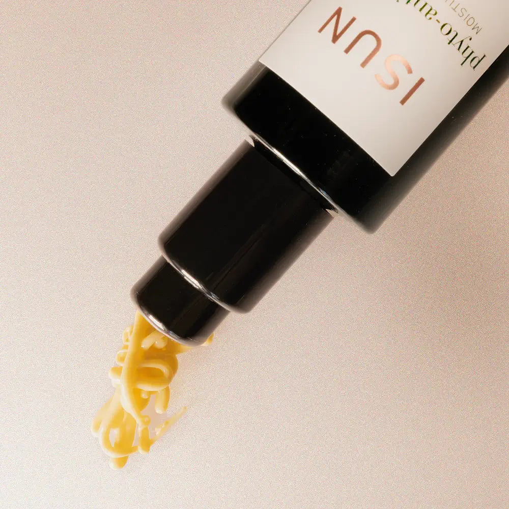 ISUN skincare product with yellow serum being dispensed onto a beige background