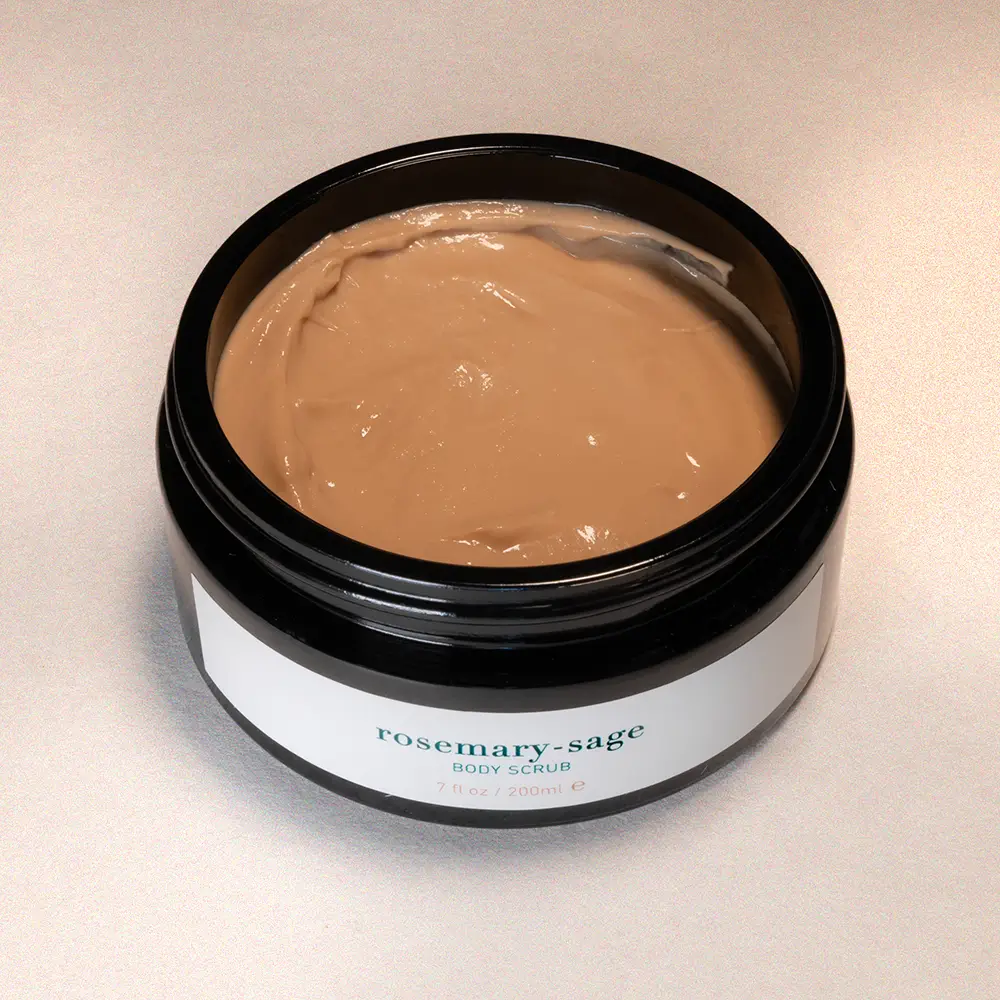 Jar of rosemary-sage body scrub on a beige background