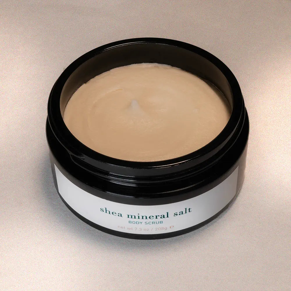 Jar of shea mineral salt body scrub on a neutral background